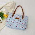 Borsa tote in tela azzurra con stampe di ciliegie rosse e tracolle in pelle marrone - Blu