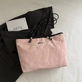 Pink oversized tote bag with wrinkled texture and black leather straps on a white background - Pink Without Pendant