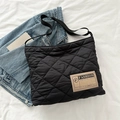 Borsa tote trapuntata nera con motivo a rombi ed etichetta moda su sfondo bianco - Nero
