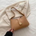Fashionable camel baguette shoulder bag with stylish gold hardware on a beige blazer - Khaki