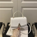 Borsa a tracolla bianca in stile francese con fibbia a V dorata su una sedia - Bianco