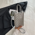 Schicke silberne gewebte Mini-Umhängetasche mit Metallic-Finish und Griff auf schwarzem Blazer - Silber