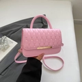 Bolso bandolera acolchado rosa con diseño de ondas y cierre dorado en escena de estilo - Rosa