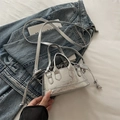 Mini zilveren crossbodytas met krokodillenprint en trekkoord op een denim spijkerjas - Zilver