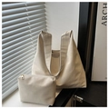 Detail of minimalist beige faux leather tote set with matching pouch on a black table - Beige White Solid Color