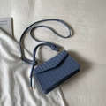 Detail der blauen Handtasche mit Webstruktur, Goldbeschlägen und geknotetem Griff - Blau