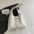 Chic beige hobo shoulder bag featuring large silver studs and adjustable strap detail - White