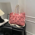 Pink corduroy tote bag with black bow print and quilted pattern in cozy home setting - Pink