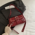 Dark red underarm bag with silver studs and adjustable strap on a gray suit jacket - Red