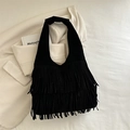 Fashionable black hobo bag with long fringes and retro aesthetic in a lifestyle setting - Black