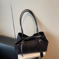 Minimalist black suede tote bag with leather straps on a book in a stylish studio setting - Black