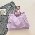 Borsa tote testurizzata viola chiaro con patch TIDE COCO su sfondo minimalista chic - Viola
