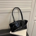 Borsa a spalla in vernice nera lucida con fibbie su sfondo di persiane bianche - Nero