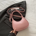 Pink crescent hobo bag with adjustable strap on a black blazer background - Pink