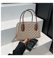 Dettaglio della borsa beige trapuntata con cuciture a V e manici marroni a contrasto - Cachi