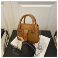 Detail of a brown leather mini handbag featuring silver buckle and elegant chain strap - Brown