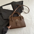 Minimalist mocha brown leather handbag featuring a signature buckle and adjustable strap - Brown