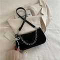 Chic black matte baguette bag with silver chain and pearl bow charm on beige blazer - Black