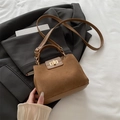 Brown vintage handbag with suede splicing and golden lock on a gray blazer outfit - Brown