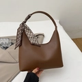 Brown leather half-moon shoulder bag with patterned silk scarf on white fabric - Brown