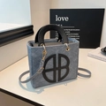 Chic grey wool tote bag with black leather handles and shoulder strap in a cozy setting - Blue