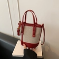 Contrastkleurige canvas bucket bag in rood en beige met leren handvatten en goud decor - Rood