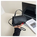 Mini bolso de mano de cuero negro sostenido junto a una laptop para mostrar la escala - Negro