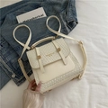 Cream white woven leather backpack with gold buckle and adjustable straps in lifestyle setting - White