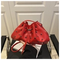 Detalle del bolso de cubo rojo con remaches y cuero sintético PU con textura - Rojo