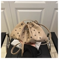 Detalle del bolso tipo saco beige con remaches plateados y cierre de cordón - Caqui
