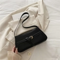 Bolso de hombro minimalista en cuero negro con hebilla dorada sobre blazer beige - Negro