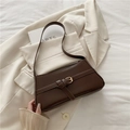 Bolso baguette minimalista marrón oscuro en cuero mate sobre un blazer elegante - Marrón