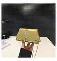 Close-up of golden leather mini bag with decorative S-shaped clasp and metal tassel detail - Gold