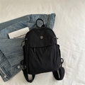 Mochila minimalista de nylon negro ligero con logo metálico en estilo casual chic - Negro