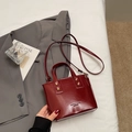 Sac seau en cuir rouge foncé avec poignées et bandoulière réglable de couleur bordeaux - Bordeaux