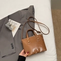 Braune Beuteltasche aus Kunstleder mit Tragegriffen und Gurt im urbanen Stil - Braun