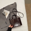 Dunkelbraune Eimer-Handtasche aus glänzendem Kunstleder mit Tragegriffen und Schultergurt - Kaffeebraun