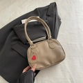Sac à main minimaliste en cuir litchi kaki avec breloque cœur sur un blazer gris - Kaki