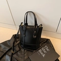Minimalistische schwarze Eimertasche aus Kunstleder mit goldenen Details und Gurt - Schwarz