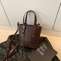 Minimalistische dunkelbraune Beuteltasche mit verstellbarem Gurt und Goldakzenten - Braun