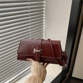 Chic burgundy patent leather baguette bag with silver buckle and knot strap detail - Red