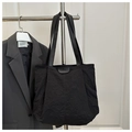 Detalle de bolsa tote negra plisada con etiqueta FASHION y correas de hombro - Negro