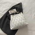 White quilted tote bag with golden chain strap on black blazer for stylish look - White