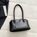Minimalist black leather tote bag with smooth finish and slender handles on white fabric - Black