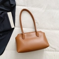 Minimalist caramel brown PU leather tote bag on white fabric background for women - Brown