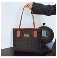 Dettaglio della borsa tote trapuntata nera con manici in pelle marrone e logo - Nero
