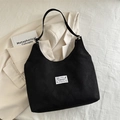 Sac fourre-tout noir minimaliste avec étiquette de mode blanche et large bandoulière - Noir
