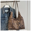 Détail du sac cabas imprimé léopard avec large bandoulière suspendu à un rack métal - Kaki