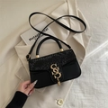 Retro black crossbody bag featuring snake texture embossing and a golden tassel lock - Black