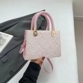 Light pink textured fabric handbag with woven handle and gold hardware in hand - Pink